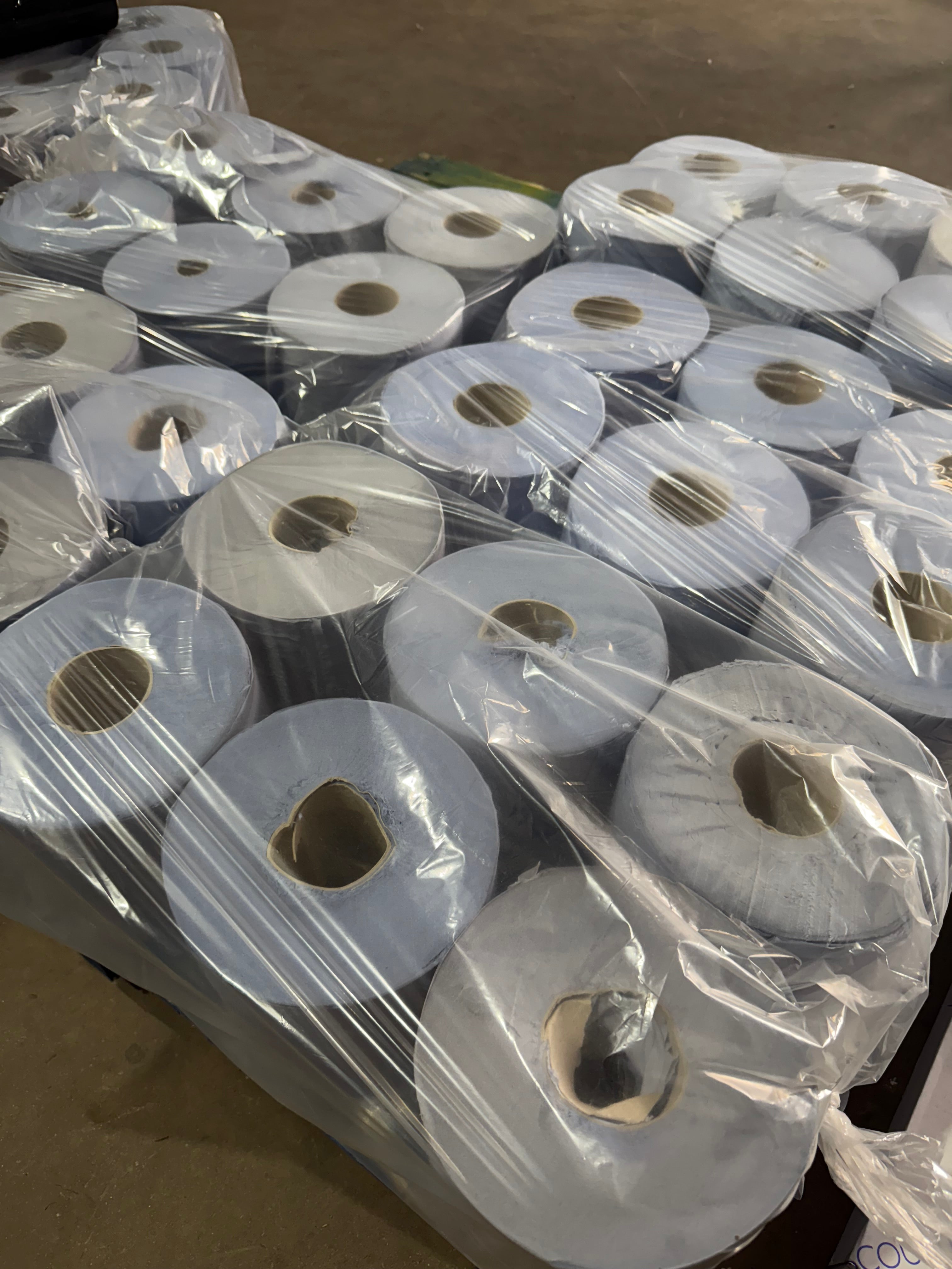 Multiple rolls of blue centrefeed tissue  stacked together, wrapped in clear plastic.