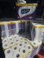 Packs of toilet rolls with visible branding on a dark background